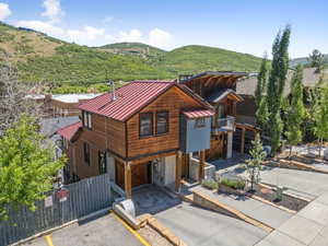 Chalet / cabin featuring a standing seam roof, a metal roof, a mountain view, and stone siding