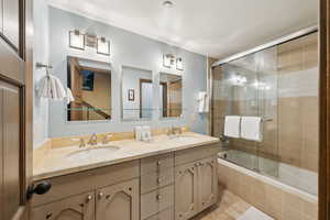 Full bathroom featuring tiled shower / bath combo and double vanity