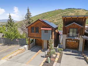 Chalet / cabin featuring a mountain view, roof mounted solar panels, and a balcony