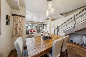 Dining space featuring wood finished floors, stairs, and recessed lighting
