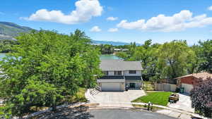 View of front of house with driveway, a garage, and a water and mountain view