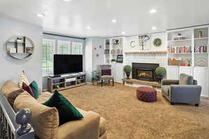 Carpeted living room featuring recessed lighting and a fireplace