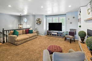 Living room featuring carpet floors, healthy amount of natural light, recessed lighting, and a textured ceiling