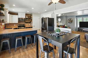 Dining room with ceiling fan, recessed lighting, and light wood-style flooring