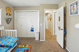 Bedroom featuring carpet and a closet