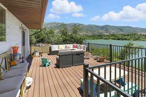 Wooden terrace featuring outdoor lounge area and a water and mountain view
