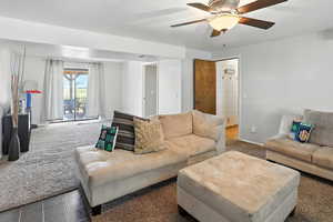Carpeted living room featuring ceiling fan
