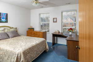 Bedroom with dark colored carpet and a ceiling fan