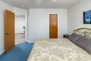 Carpeted bedroom featuring a ceiling fan and a textured ceiling