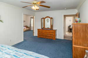 Bedroom with crown molding, carpet floors, and ceiling fan