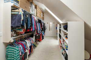 Spacious closet featuring carpet flooring and lofted ceiling