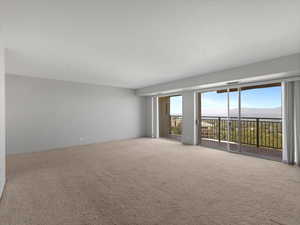 Unfurnished room with carpet floors and a mountain view