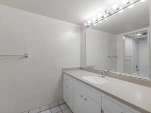 Bathroom with vanity, tile patterned floors, and washtub / shower combination