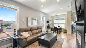 Living area with light wood finished floors and recessed lighting