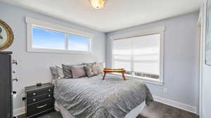 Bedroom featuring dark wood-type flooring and baseboards