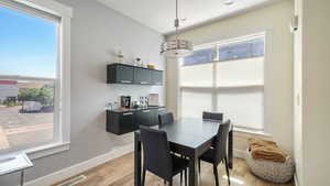Dining space featuring light wood-style floors and bar area