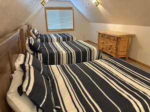 Bedroom with lofted ceiling, carpet flooring, and a ceiling fan