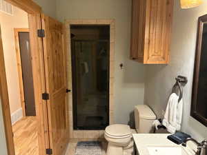 Full bath featuring vanity, a shower stall, and wood finished floors