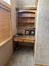 Carpeted home office featuring baseboards