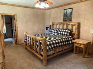 Carpeted bedroom with heating unit, a textured ceiling, and a ceiling fan