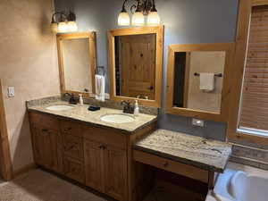 Full bath with double vanity and a tub to relax in