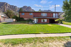 Traditional home featuring a balcony, a mountain view, concrete driveway, and brick siding