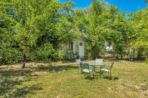 View of green lawn featuring outdoor dining space