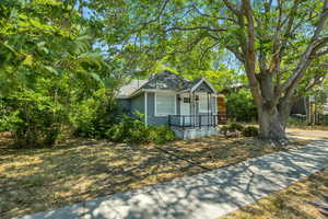 Bungalow featuring covered porch and roof with shingles