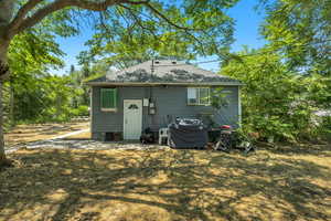 Back of property featuring a shingled roof
