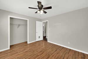 Unfurnished bedroom with wood finished floors, a closet, and ceiling fan