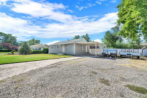 View of front of property featuring gravel driveway and a carport
