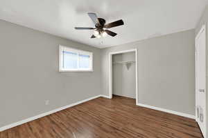 Unfurnished bedroom featuring wood finished floors, a closet, and a ceiling fan