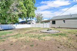 Fenced backyard with an outdoor fire pit