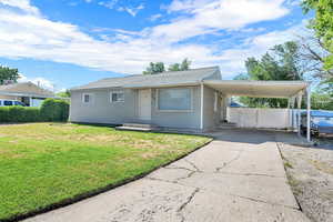 View of front of home featuring an attached carport, concrete driveway, a gate, and a shingled roof