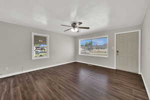 Entrance foyer with ceiling fan, a textured ceiling, and dark wood finished floors