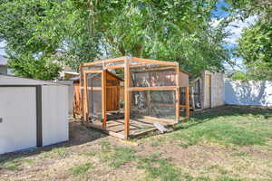 Fenced backyard featuring exterior structure and a storage unit
