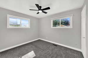 Empty room with carpet and ceiling fan