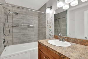 Bathroom featuring vanity and washtub / shower combination