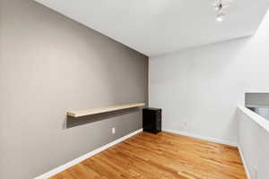 Unfurnished room featuring light wood finished floors and baseboards
