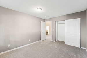 Unfurnished bedroom featuring carpet floors, a textured ceiling, and a closet