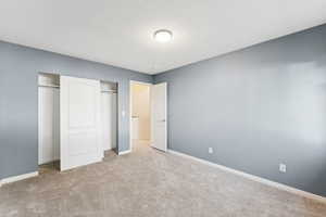 Unfurnished bedroom with carpet and a textured ceiling