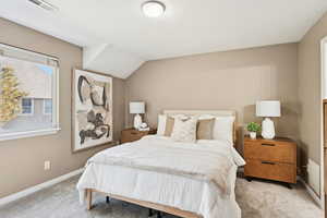 Bedroom with light colored carpet and baseboards