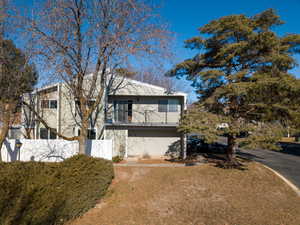 View of front facade featuring a balcony, driveway, and an attached garage