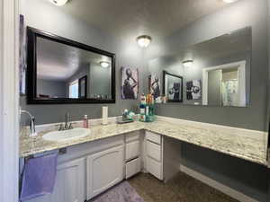 Bathroom featuring a textured ceiling and vanity