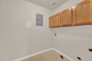 Laundry area featuring cabinet space, hookup for an electric dryer, washer hookup, and electric panel