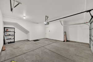 Garage with a garage door opener and baseboards