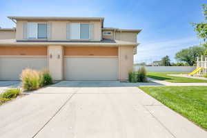 Traditional-style home with stucco siding, concrete driveway, and an attached garage