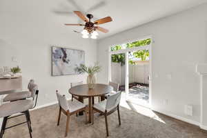 Carpeted dining space featuring baseboards and ceiling fan