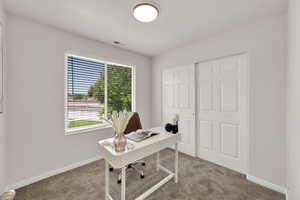 Office area featuring light colored carpet and baseboards