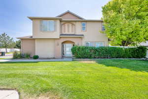 View of front of property featuring stucco siding and a front lawn